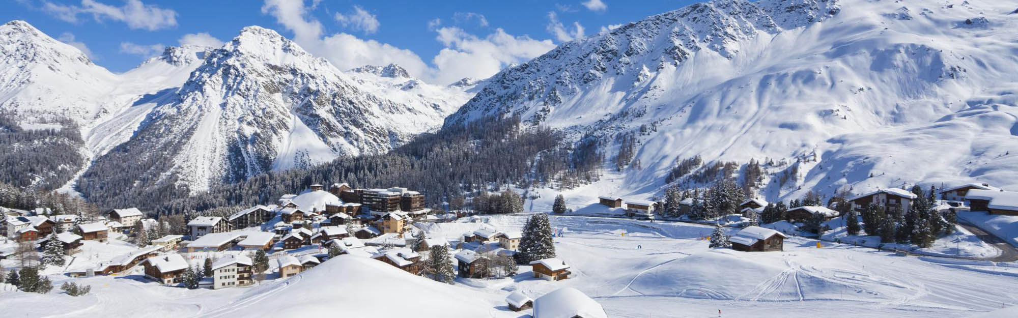 La station d'Arosa en plein jour, au pied des montagnes enneigées